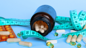 a bottle of medication lays open on a table with a tape measure