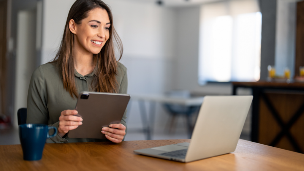 a woman sitting at a table in front of a laptop to meet with her online weight loss coach