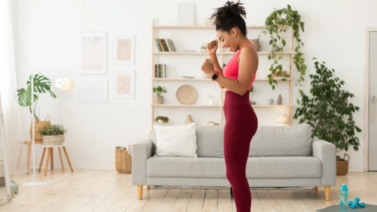 a woman stands on a scale and is excited about her weight loss